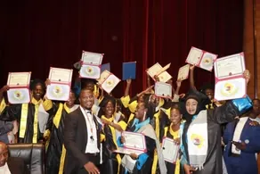 Diplômés en toge brandissant leur parchemin pendant la cérémonie de remise.