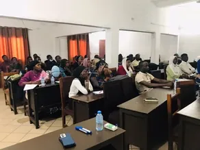 Étudiants suivant un cours, installés à des tables de travail dans une salle équipée.